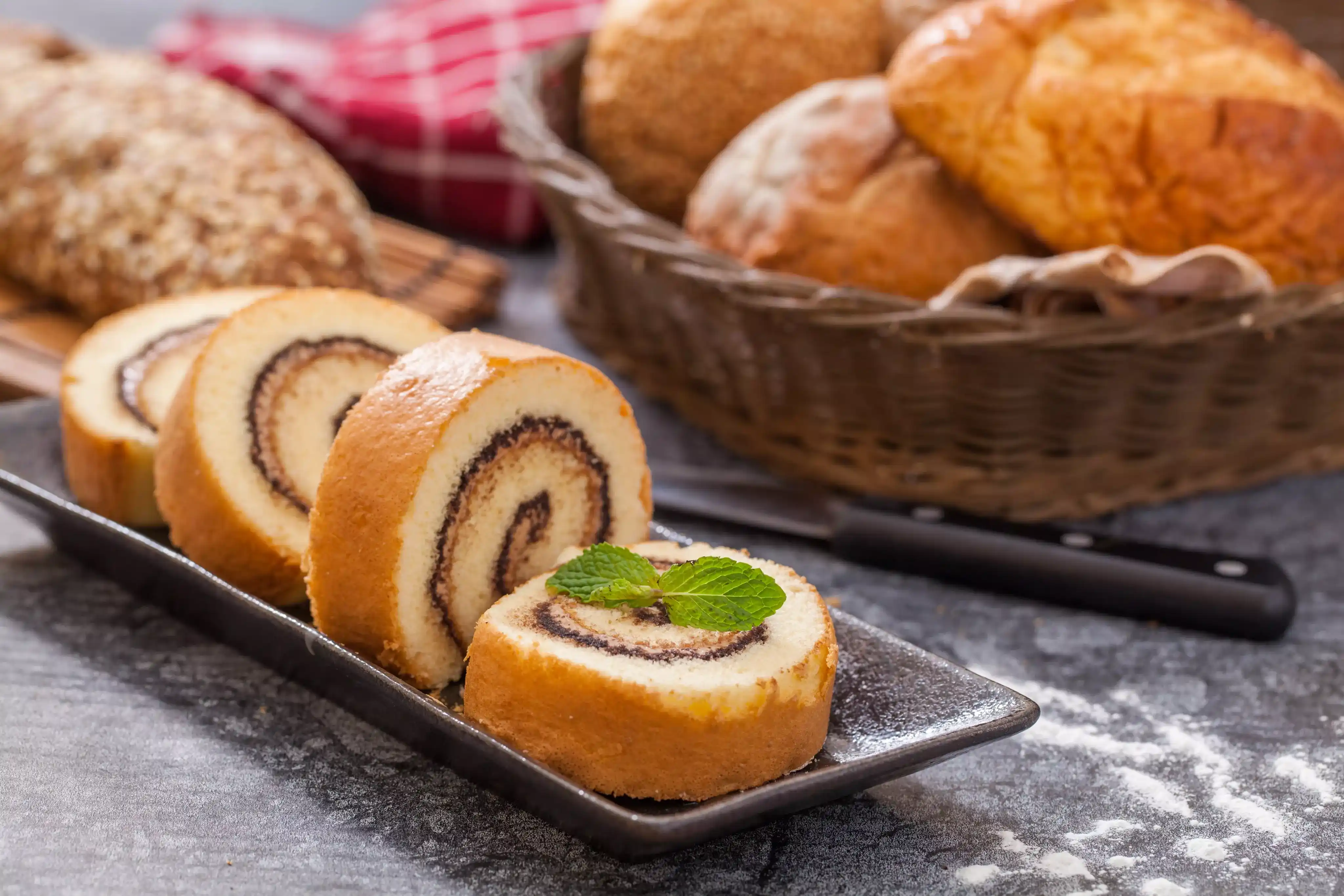Beautiful cakes and Swiss rolls with cream fillings, chocolate ganache, and fruit decorations